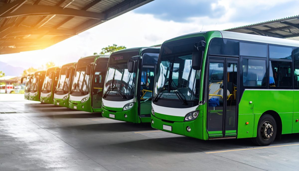 Vecteezy green bus fleet parked in row under large shelter with 69901414 scaled.jpeg