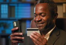 Vecteezy smiling african american businessman hold credit card remote 374711 scaled.jpg