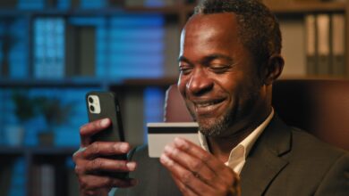 Vecteezy smiling african american businessman hold credit card remote 374711 scaled.jpg