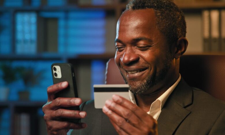 Vecteezy smiling african american businessman hold credit card remote 374711 scaled.jpg